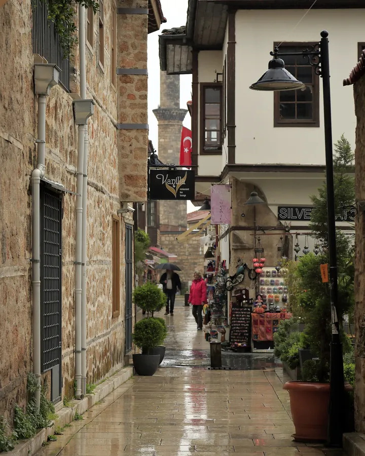 Hesapçı Sokak on a rainy day: wet paving stones between old stone houses and lamp posts